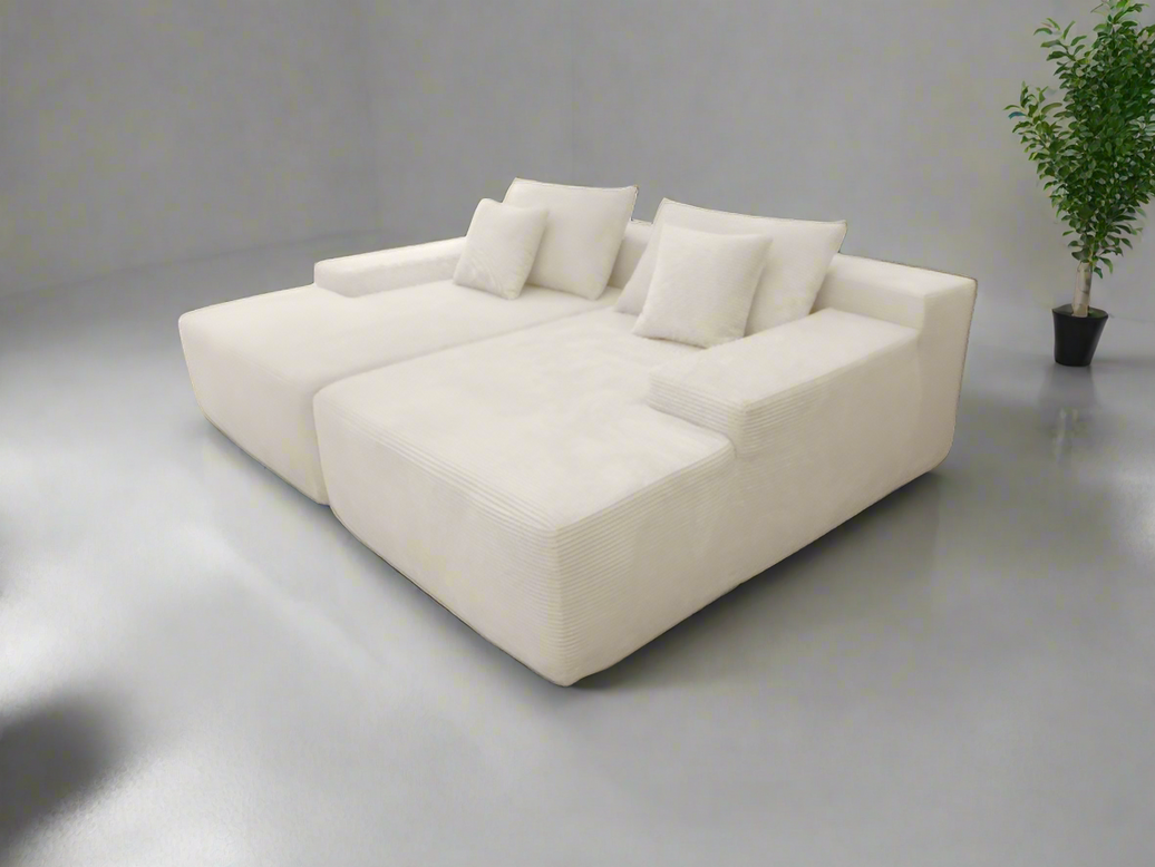 White sectional sofa in a minimalistic room with a plant.