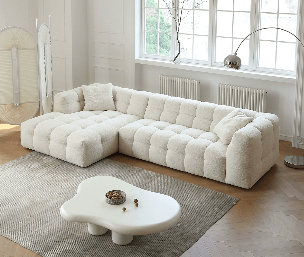 White sectional sofa in a modern living room with a coffee table and decorative items.