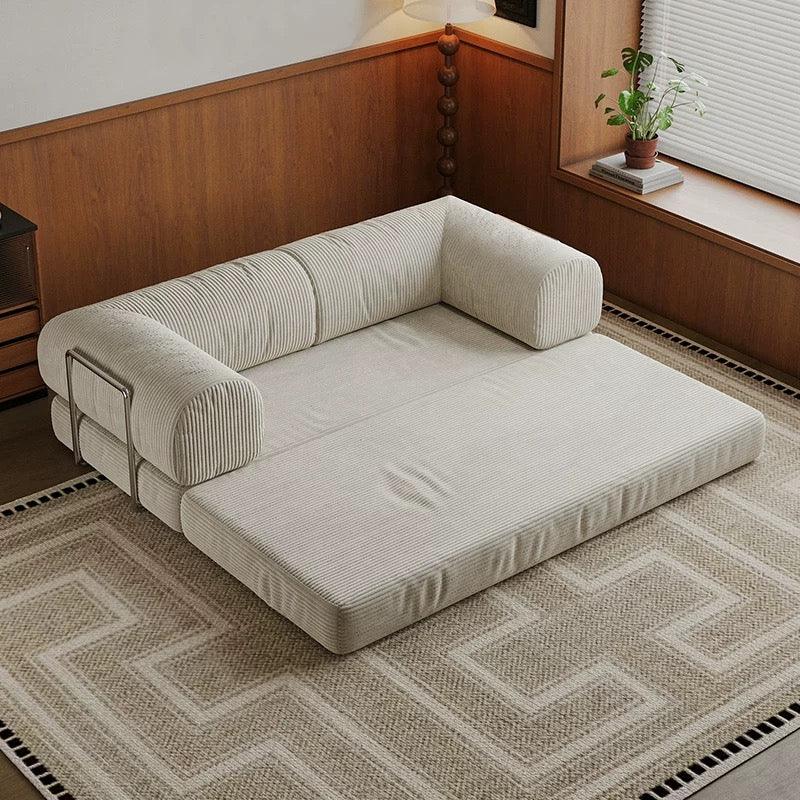 Beige sectional sofa on a patterned rug in a room with wooden walls and a plant.