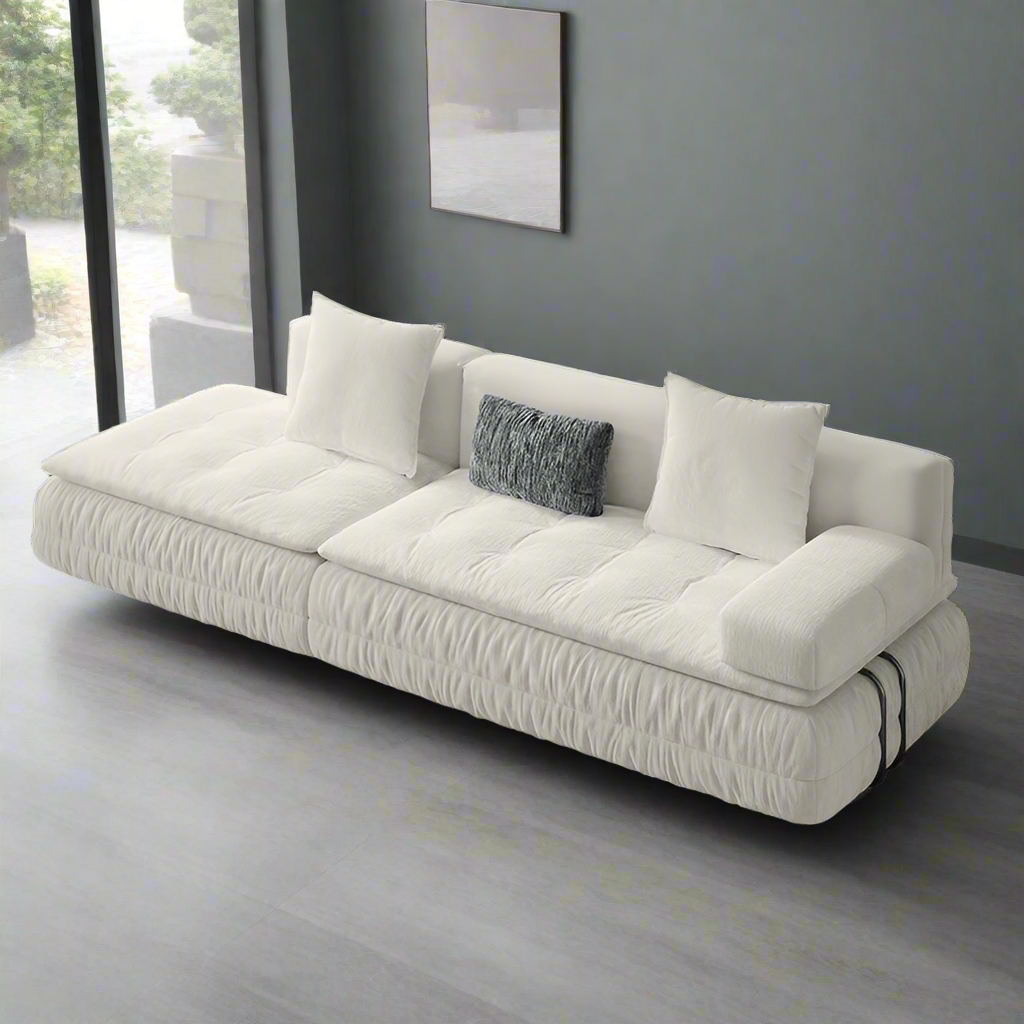 White sofa with cushions on a solid background